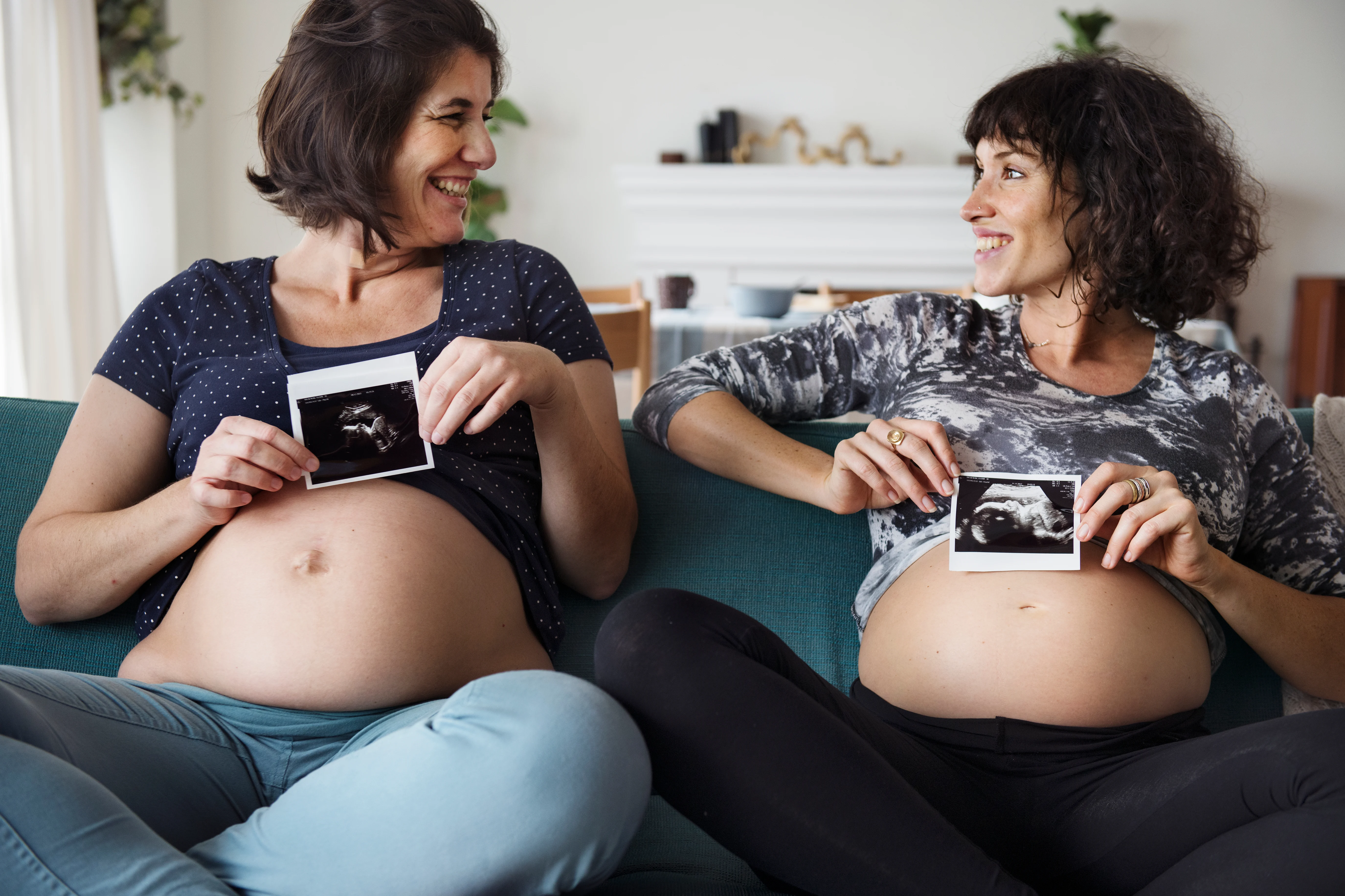 Pregnant women comparing ultrasound pictures