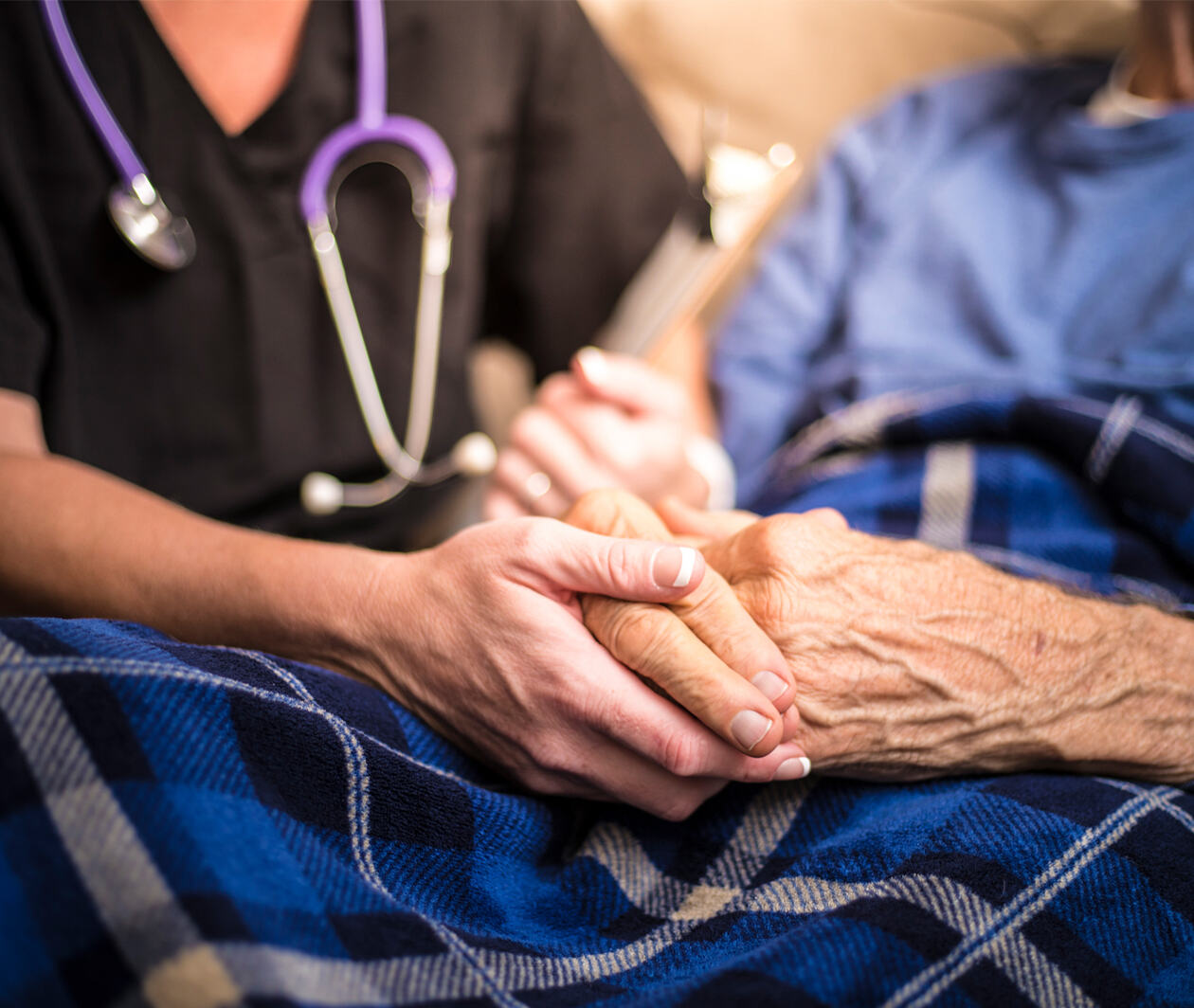 Palliative care - medical practitioner holding hands of patient