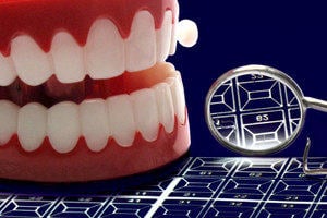 A pair of wind-up toy teeth and a dental inspection mirror