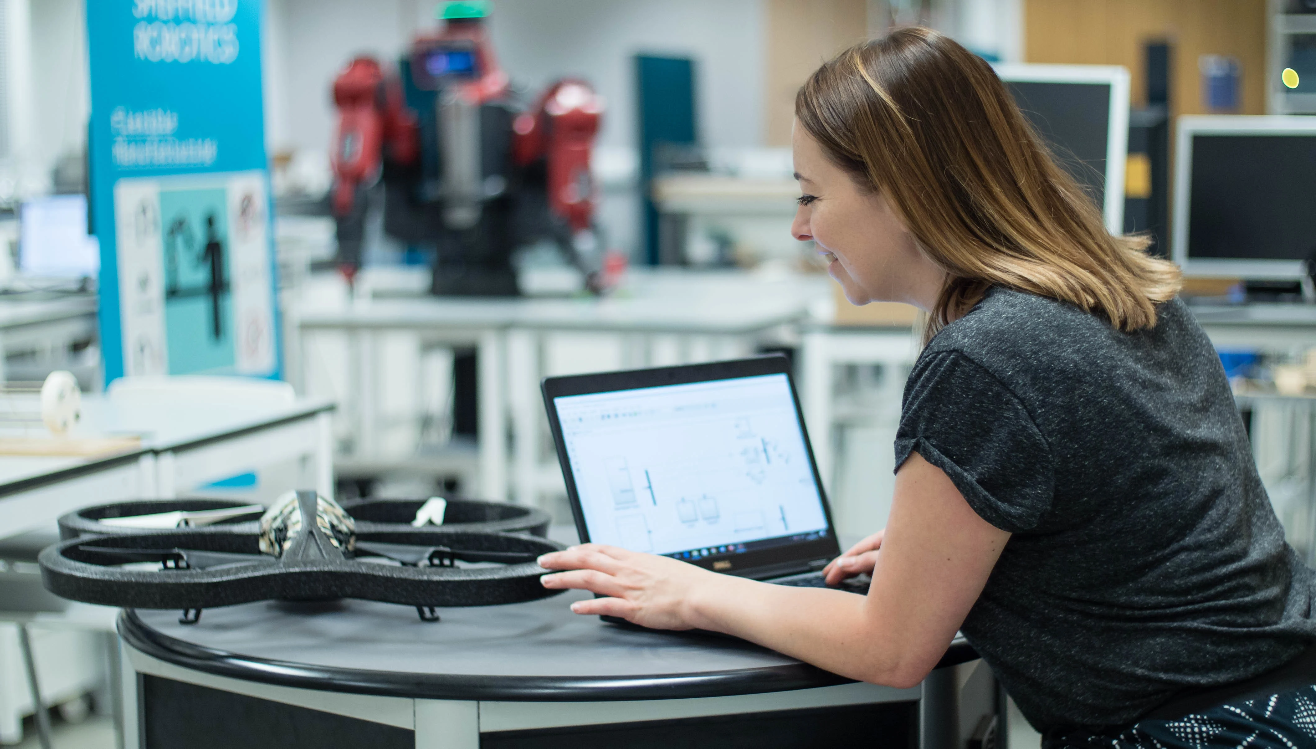 An engineer programs a drone in the robotics lab