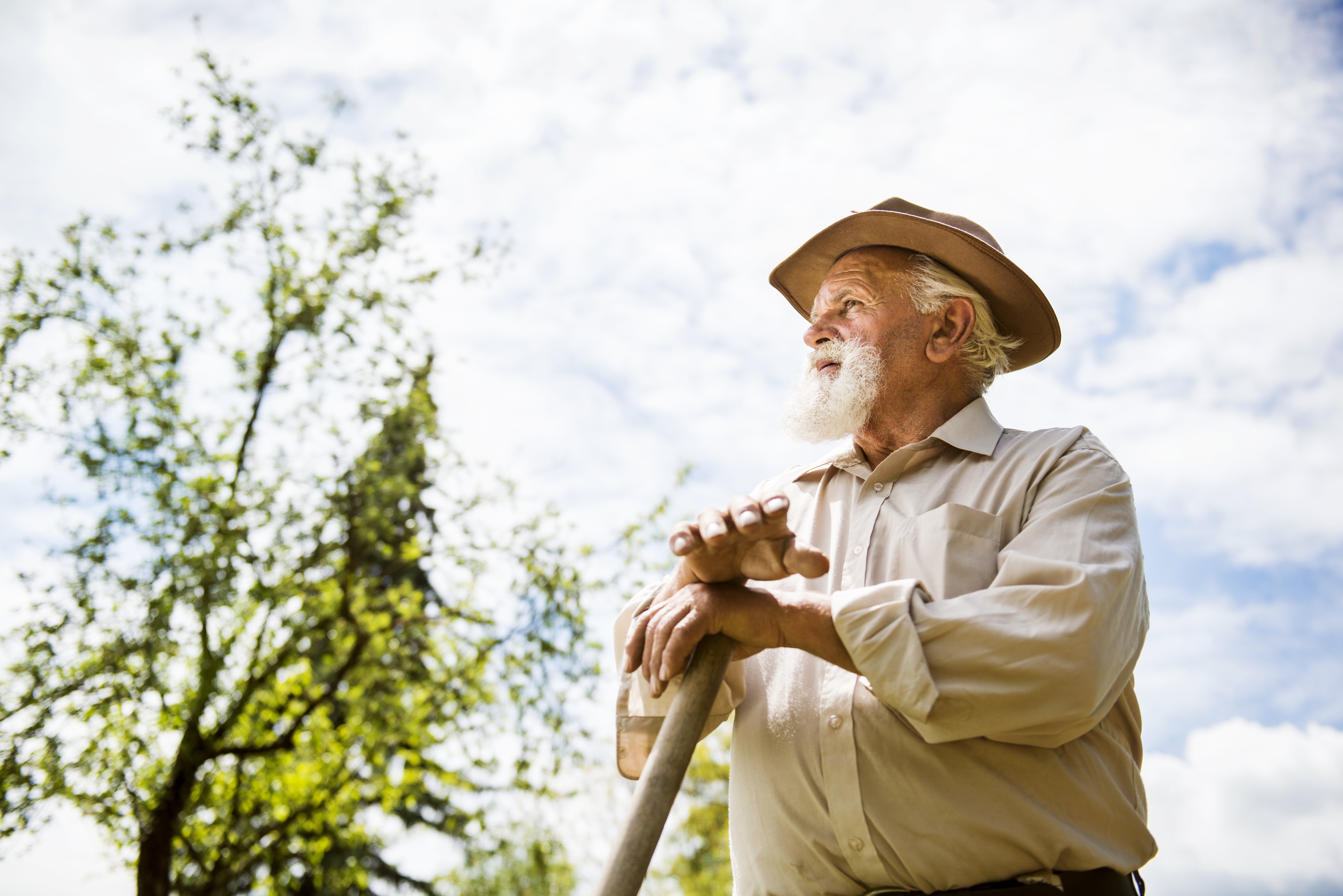 Old farmer with a hoe is having break