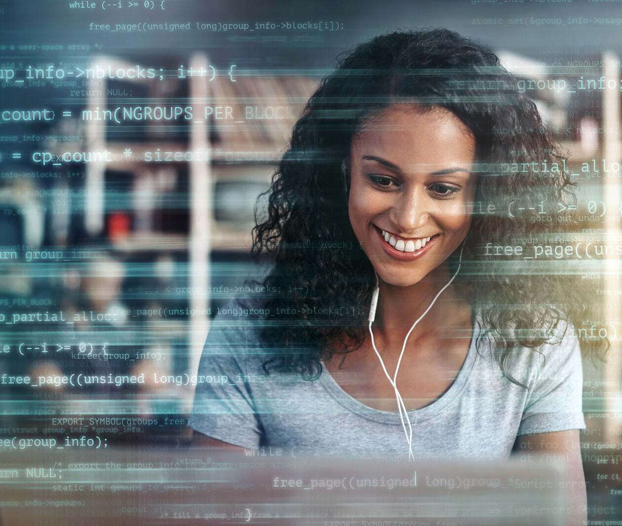 A mid-shot of a woman using a laptop superimposed over multiple lines of computer code