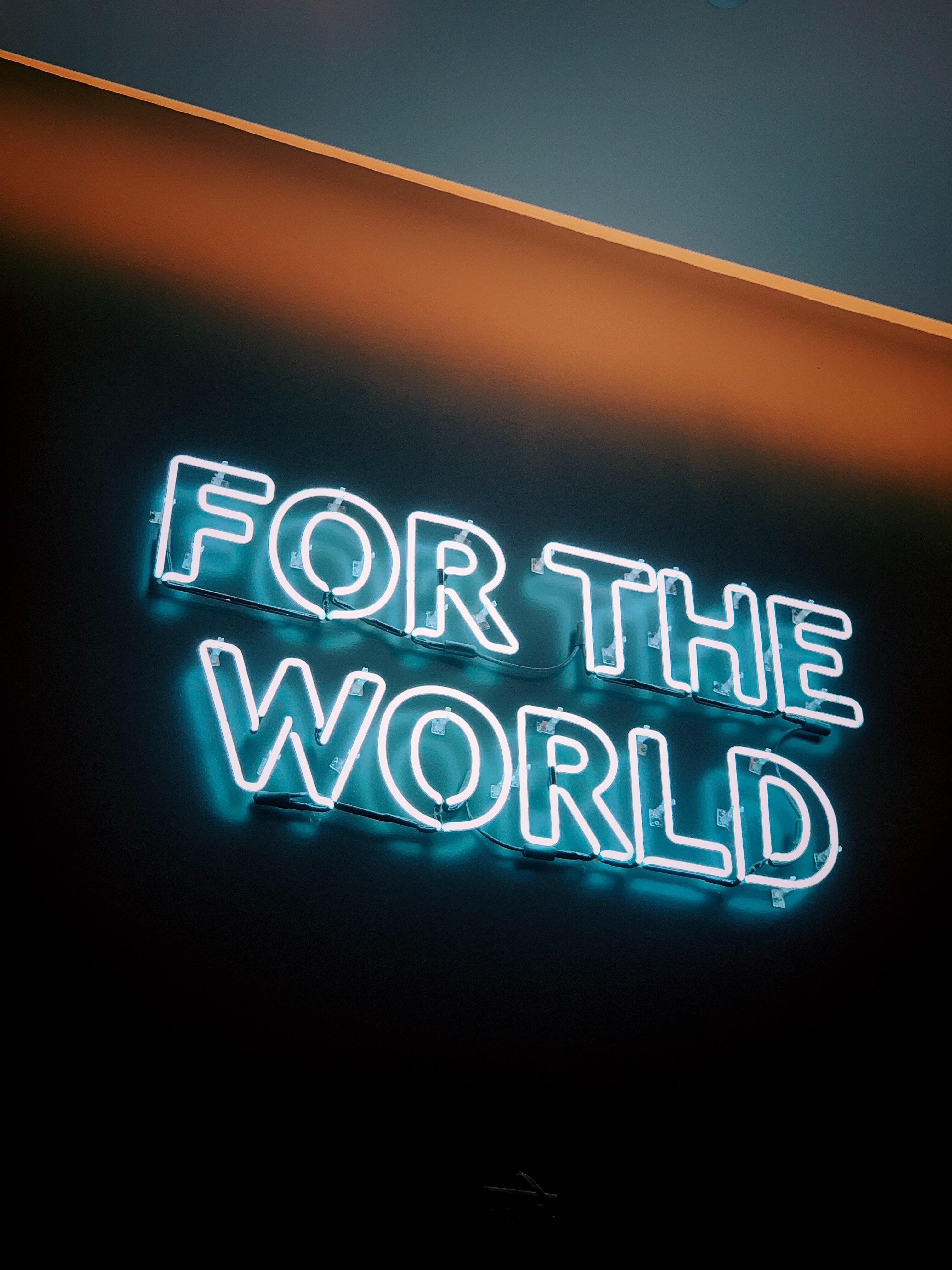 The words 'For the World' in blue neon letters on a black background.