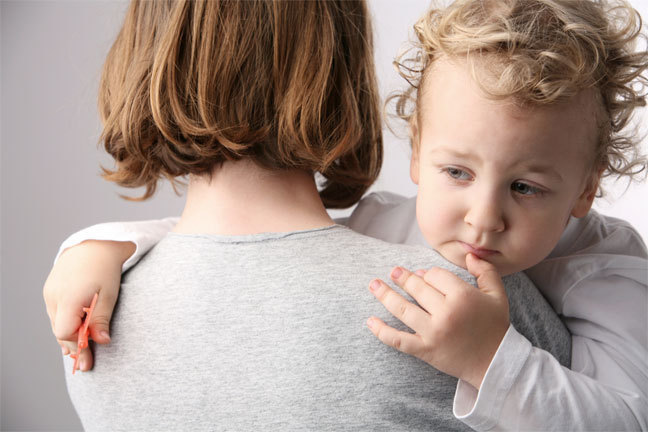 Woman carries a worried child