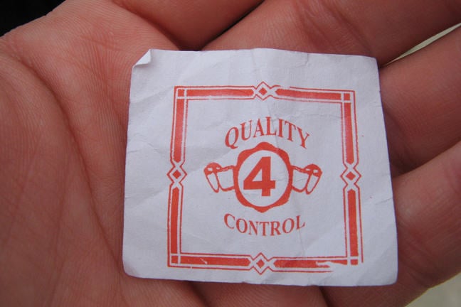 Quality control typed on a piece of paper in the palm of a hand