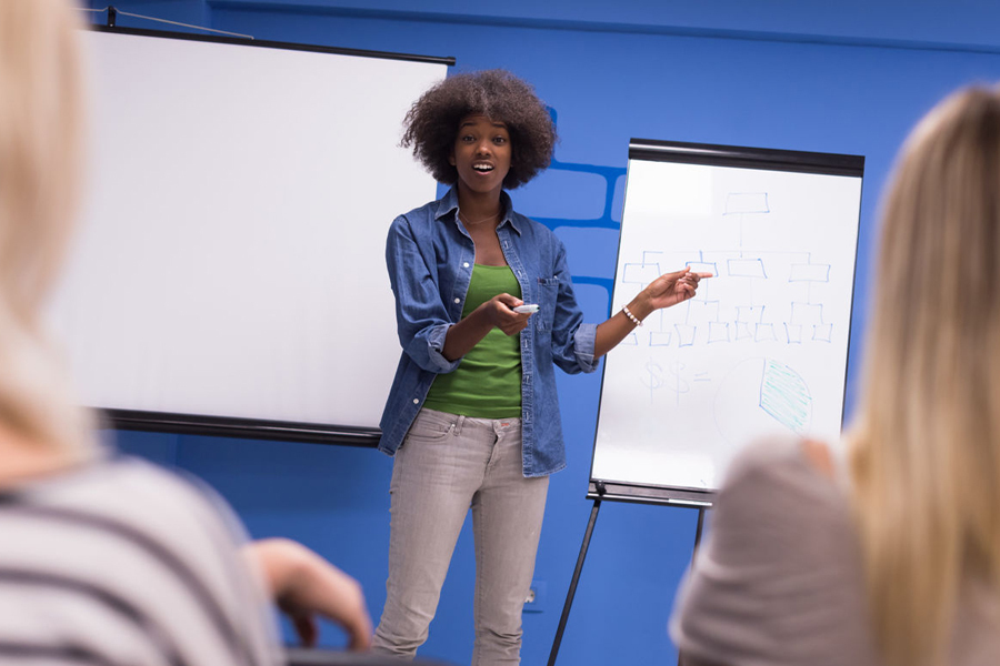 Image show a confident trainer speaking to a group