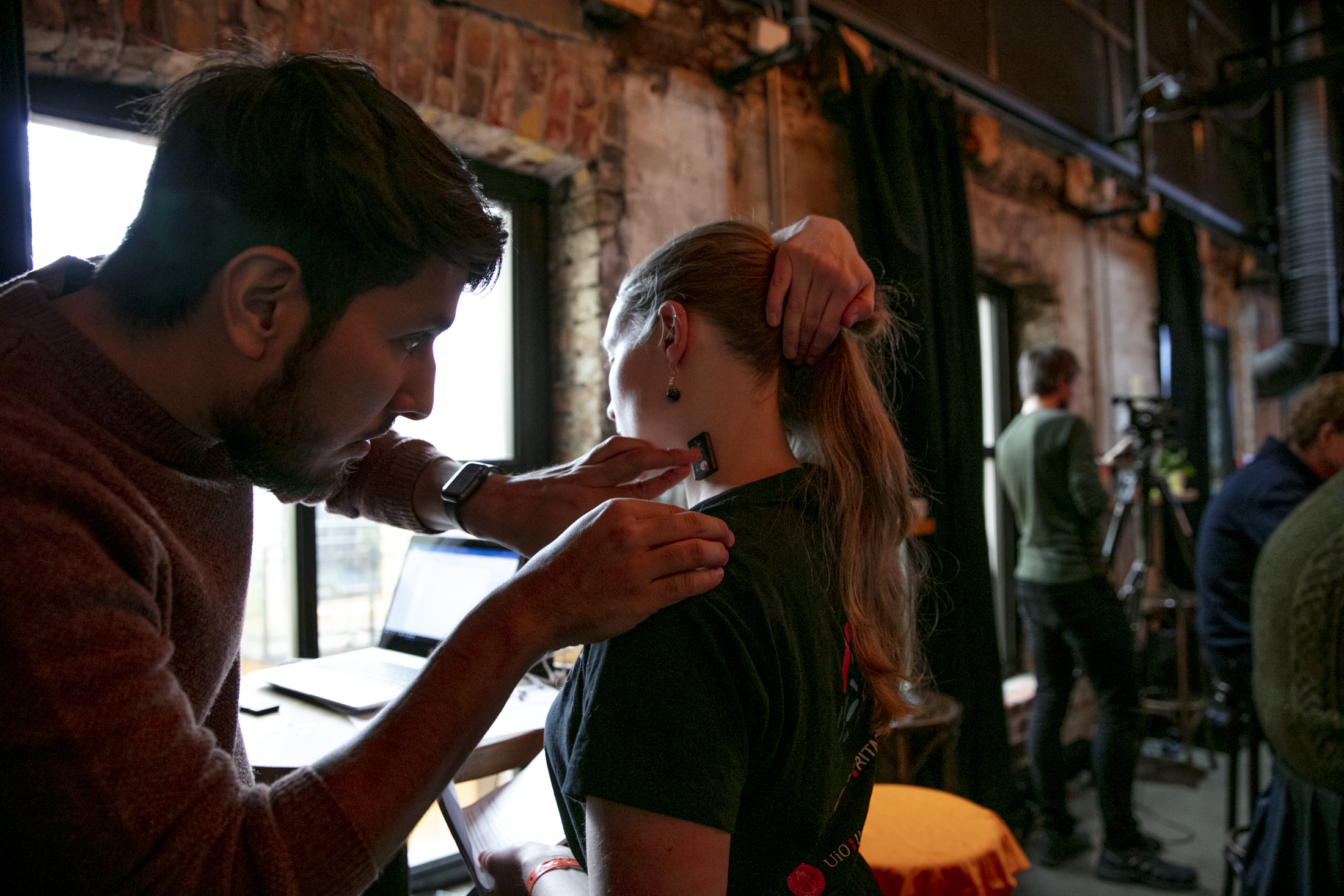 Researcher placing sensor on the neck of a participant.