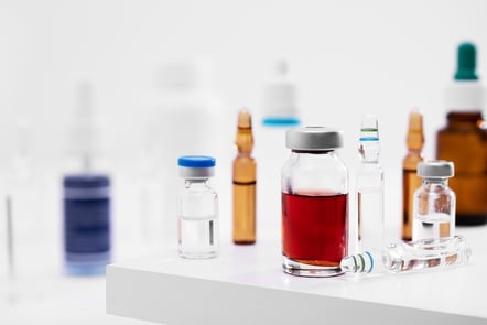 shot of different glass vials with liquids on a white surface at a lab
