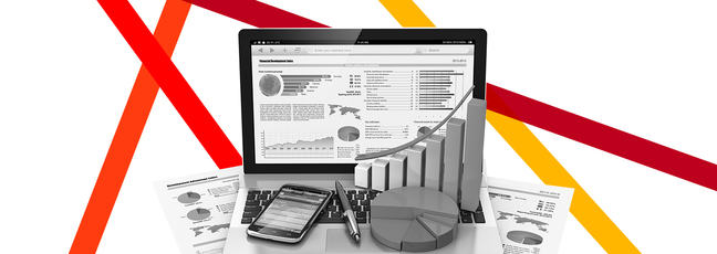 Laptop and printed documents displaying graphs and statistics