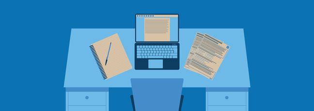 A desk during the application process with computer, note pad and CV
