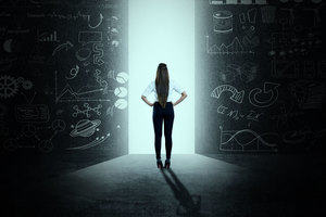 Woman standing between two blackboards with lots of illustrations