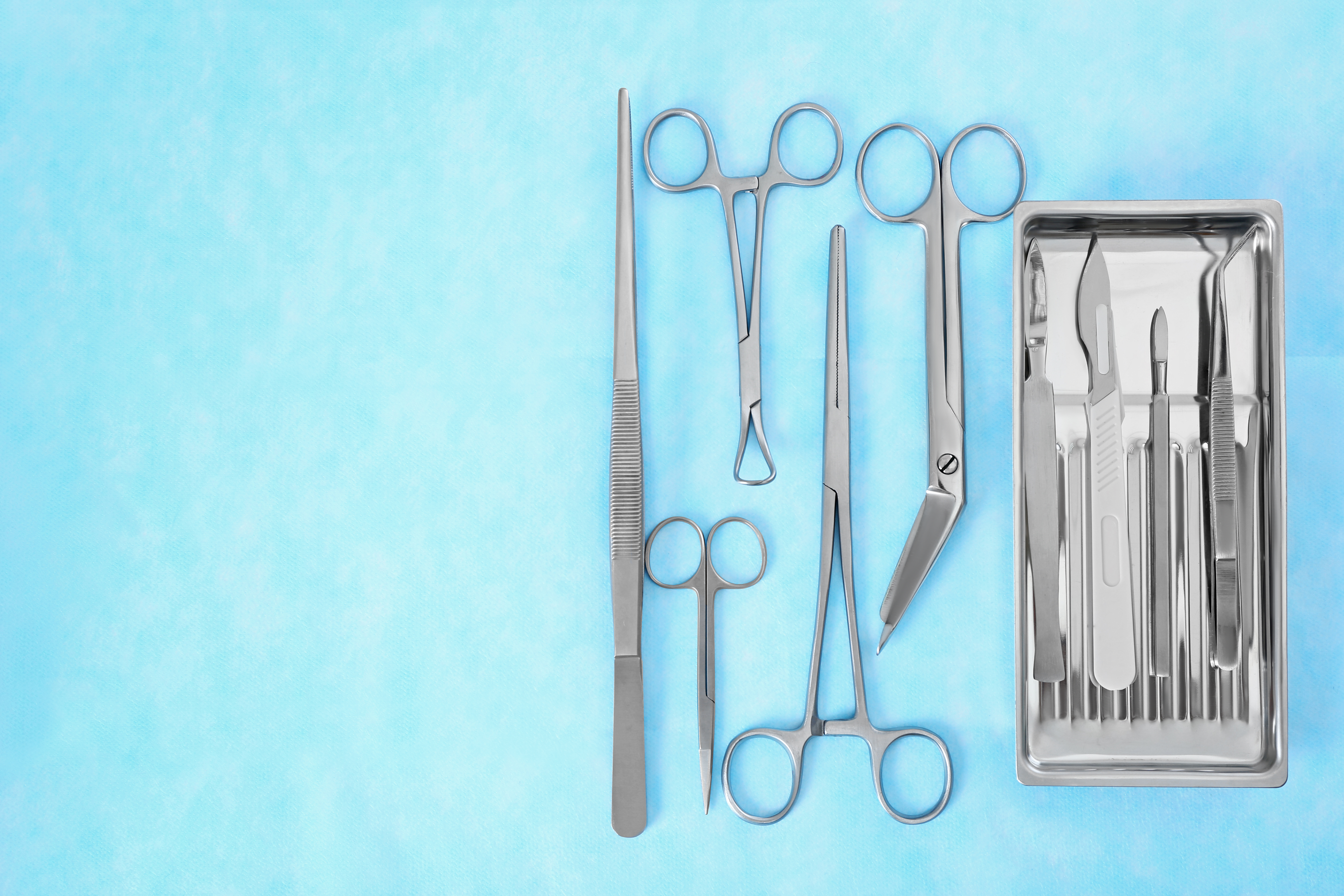 A blue background with a selection of surgical instruments.