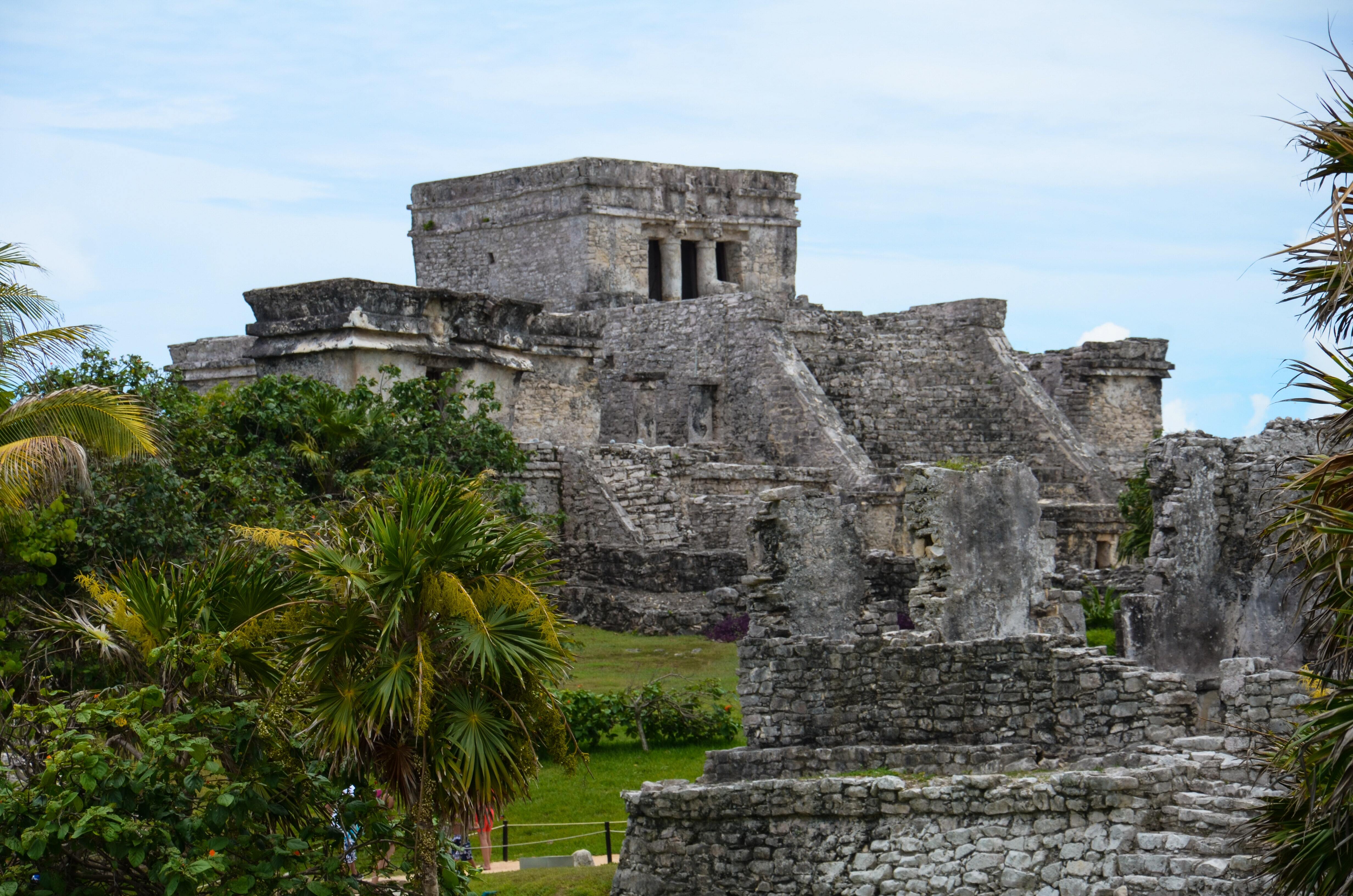 Edificio de piedra gris cerca de palmeras en Cancún.