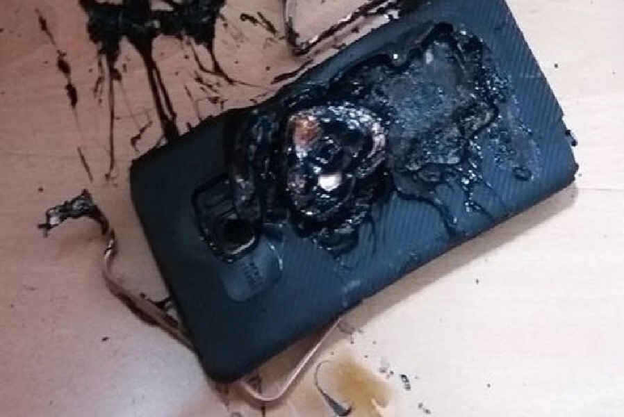 A smartphone that appears melted, apparently destroyed by fire.