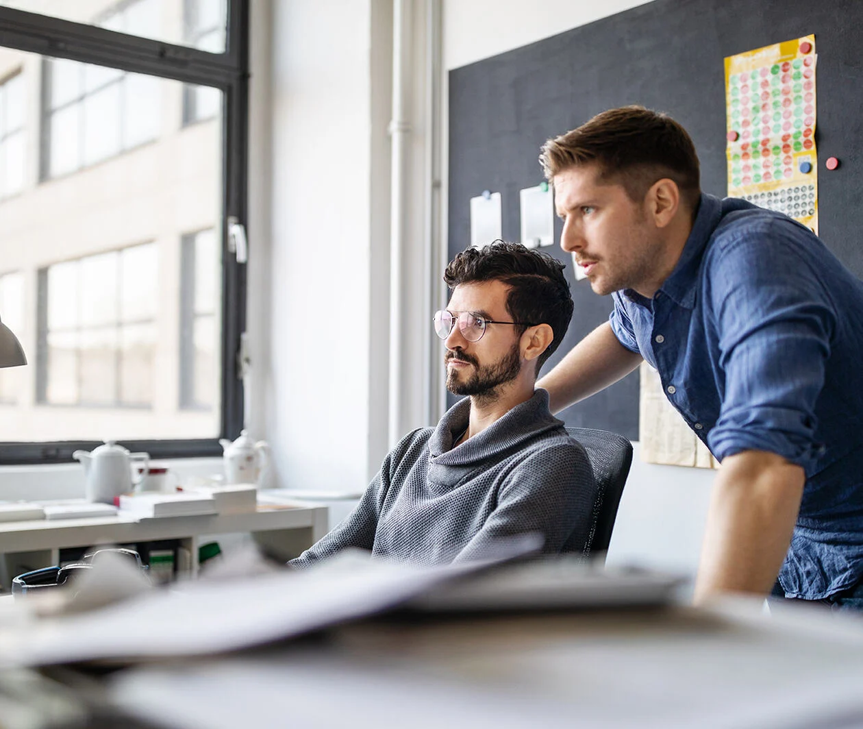 2 male business partners looking at the computer together