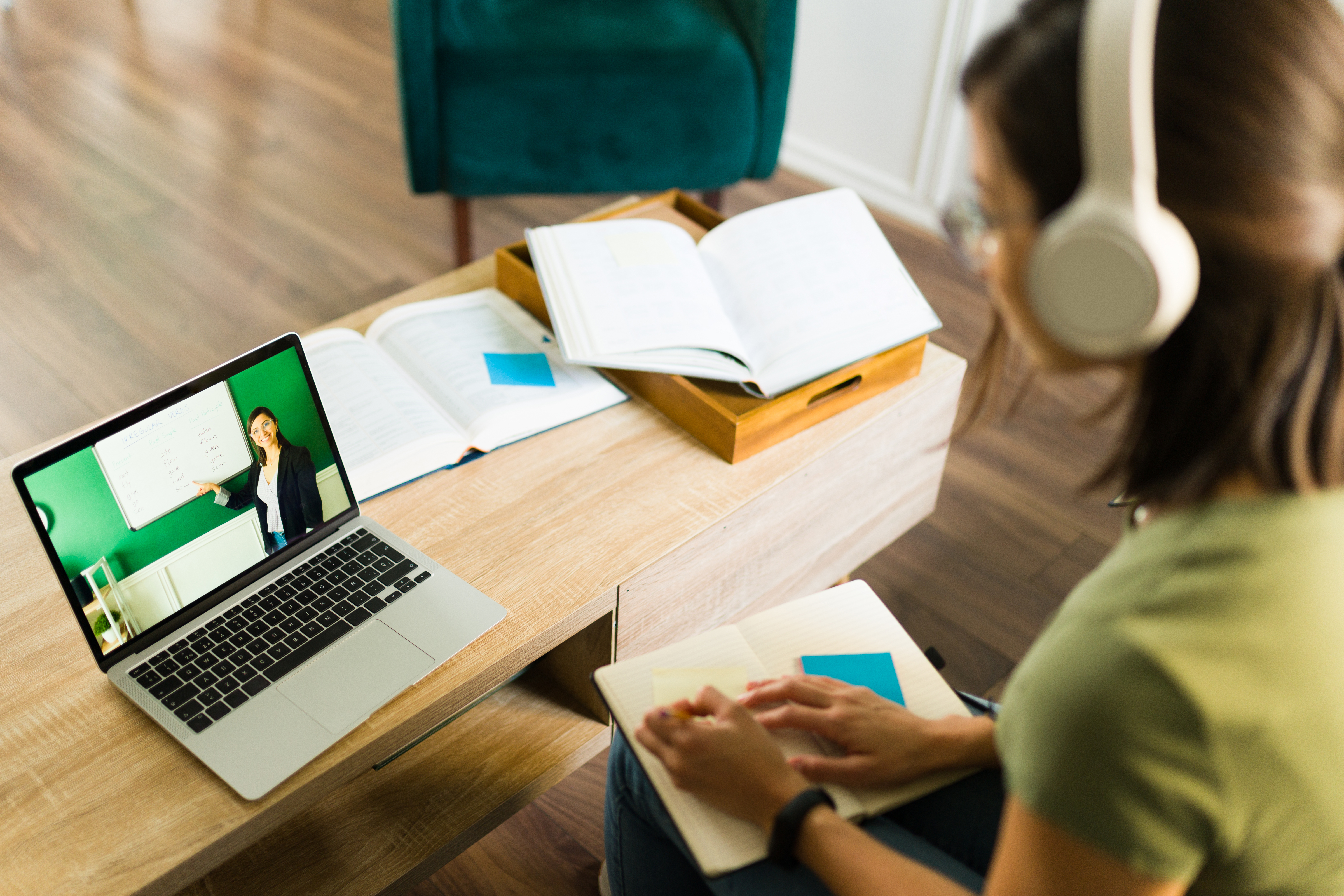 Photo rear view of a young college student paying attention and listening to her online teacher