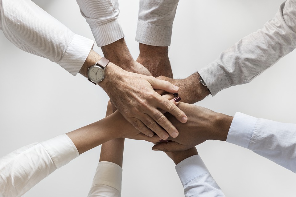 Members of a team putting hands together in a huddle