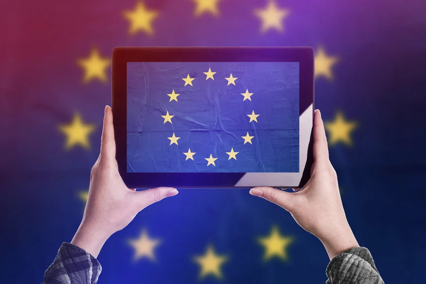 A pair of hands holding up a tablet with an EU flag on the screen