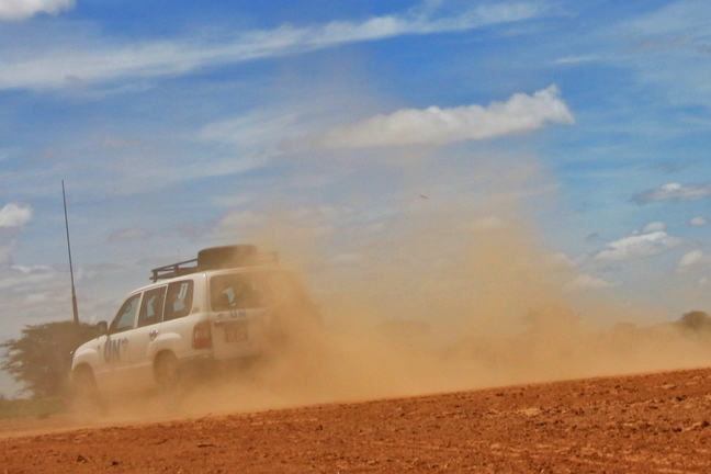 Image of jeep driving away with dust