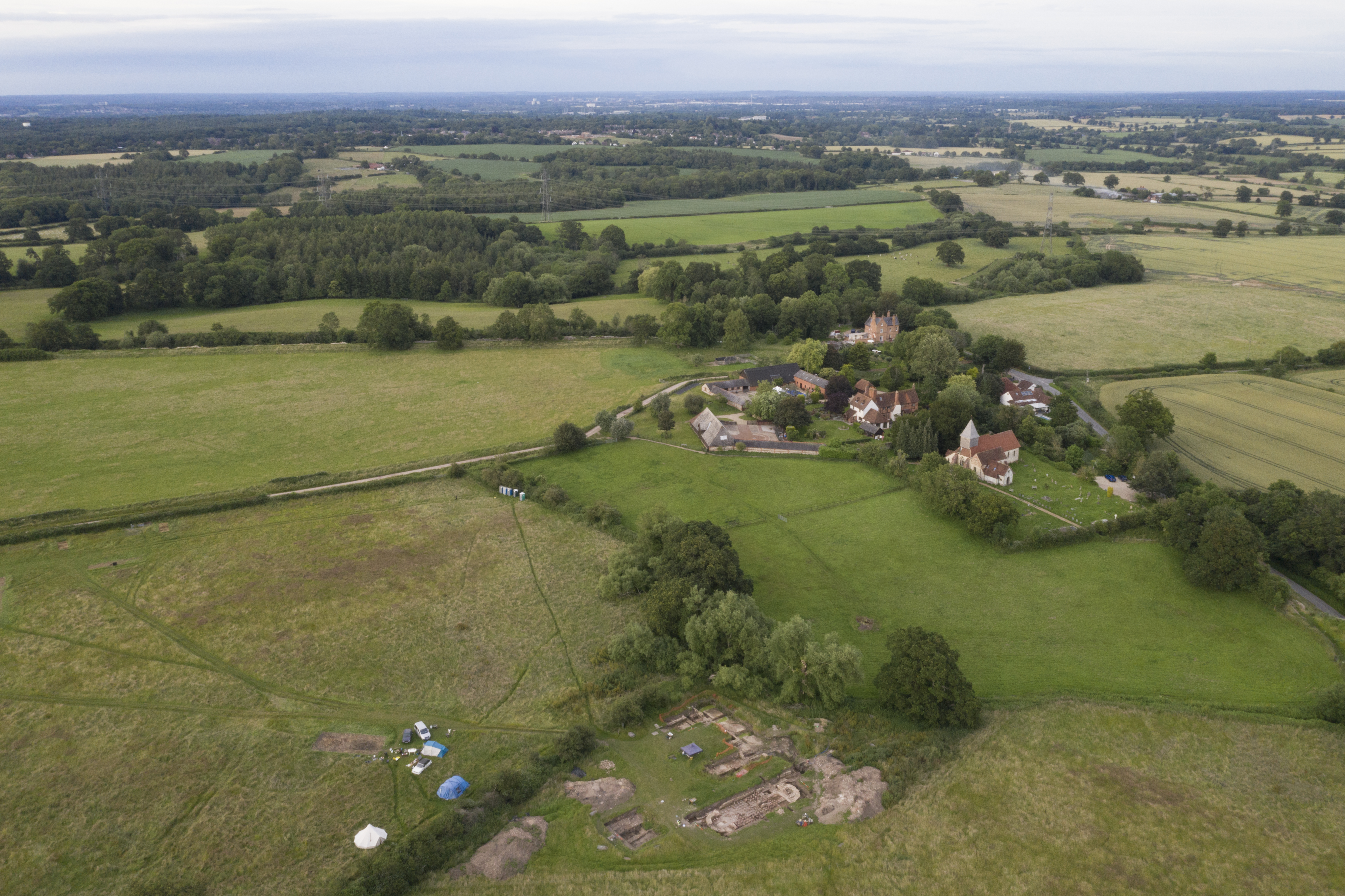 A photo of a landscape with fields and a church