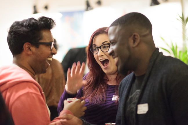Three developers chat and laugh together