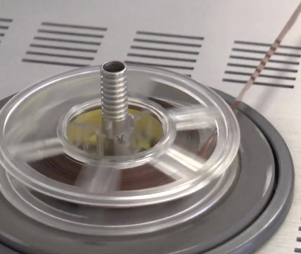 An image of a 3.75 inch reel-to-reel magnetic tape running through a tape machine