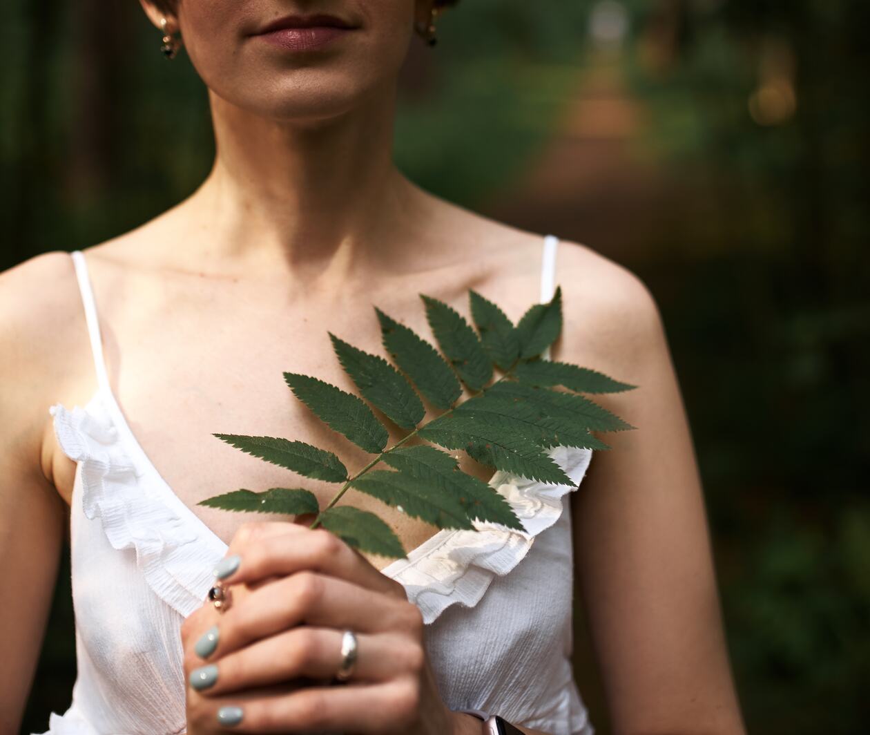 Cropped woman white top beautiful leaf in hands