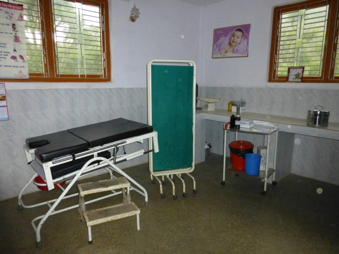 A health clinic with a bed and privacy screen is shown.