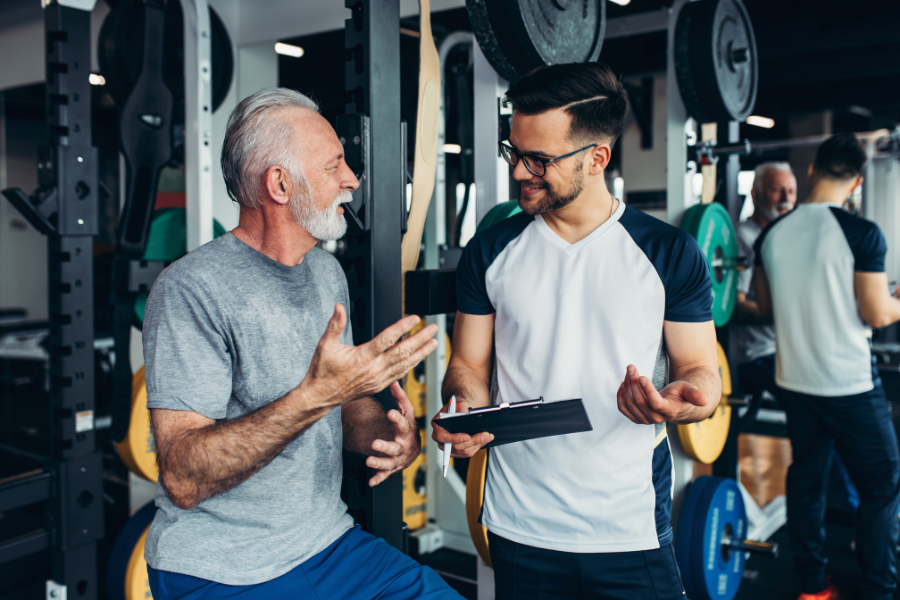 Trainer with client on gym floor