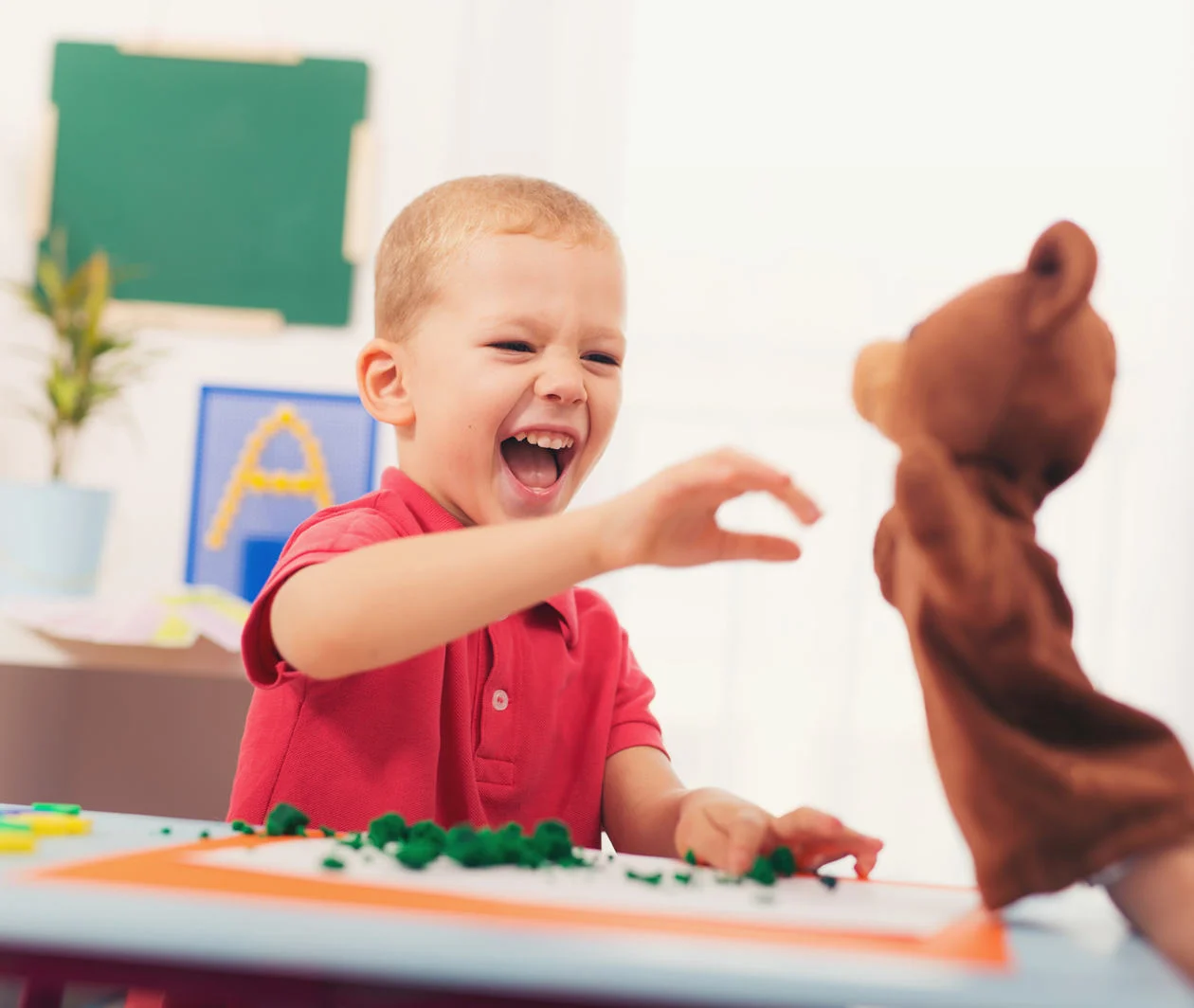 Boy interacting with puppet of a bear