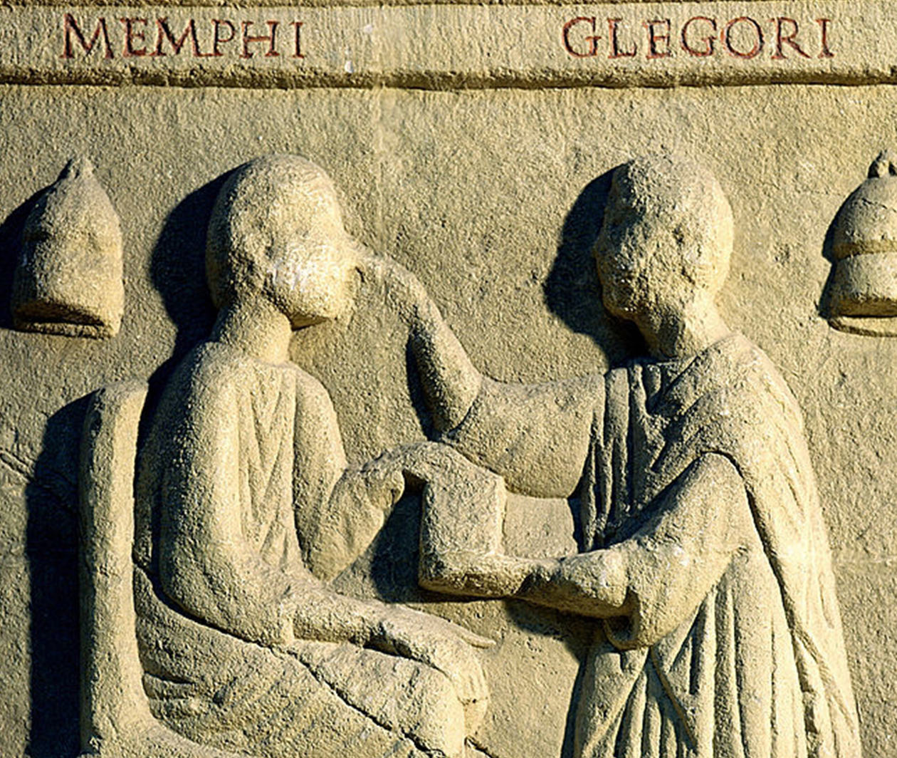 An ancient stone carving depicting a doctor treating a patient