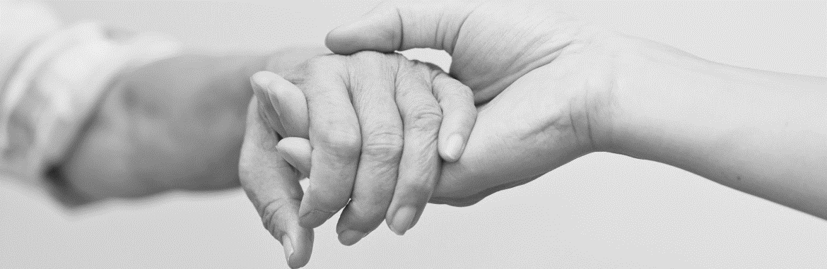 A greyscale picture showing hands of two different people holding together