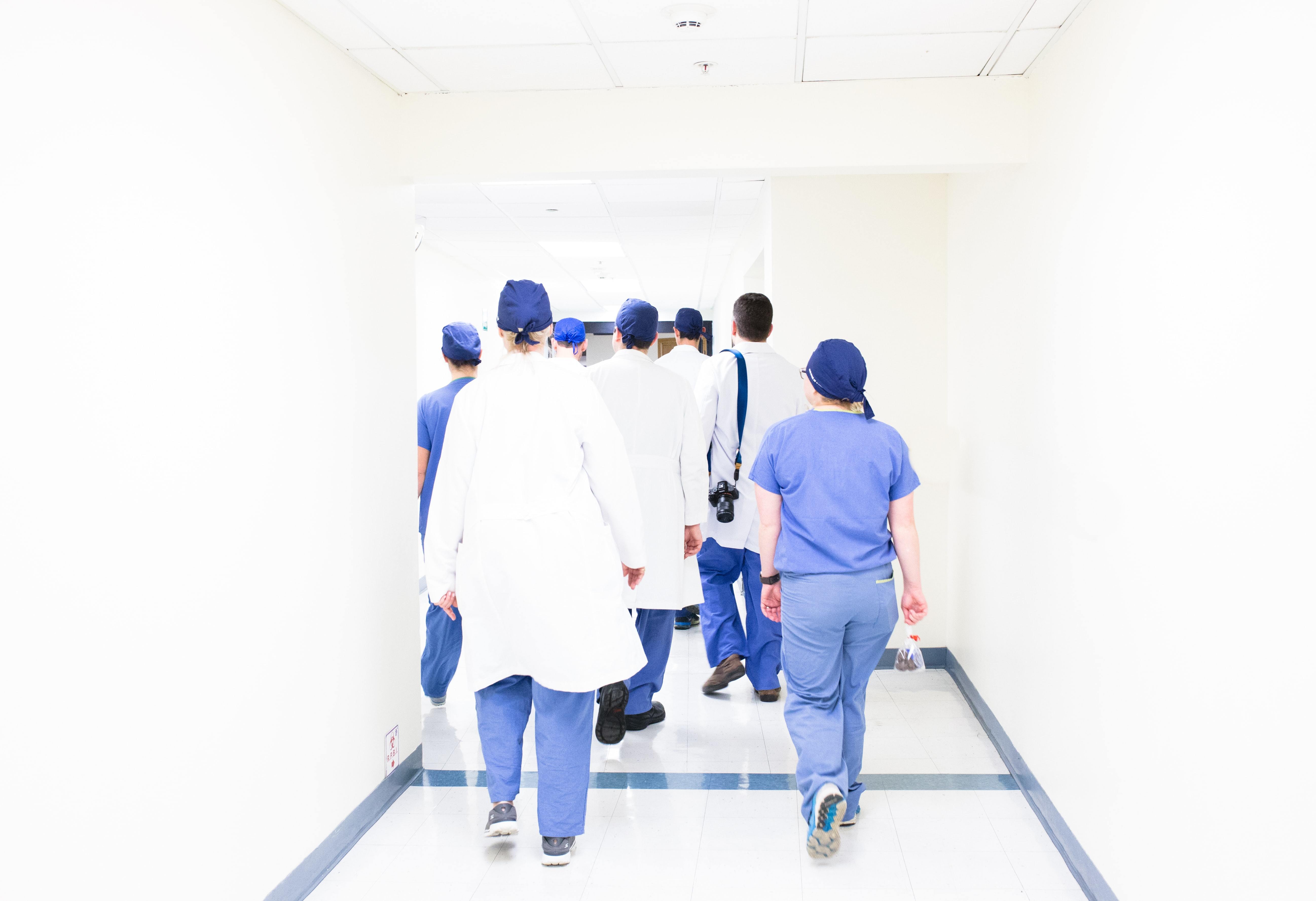 team of doctors facing away from camera, in a white room