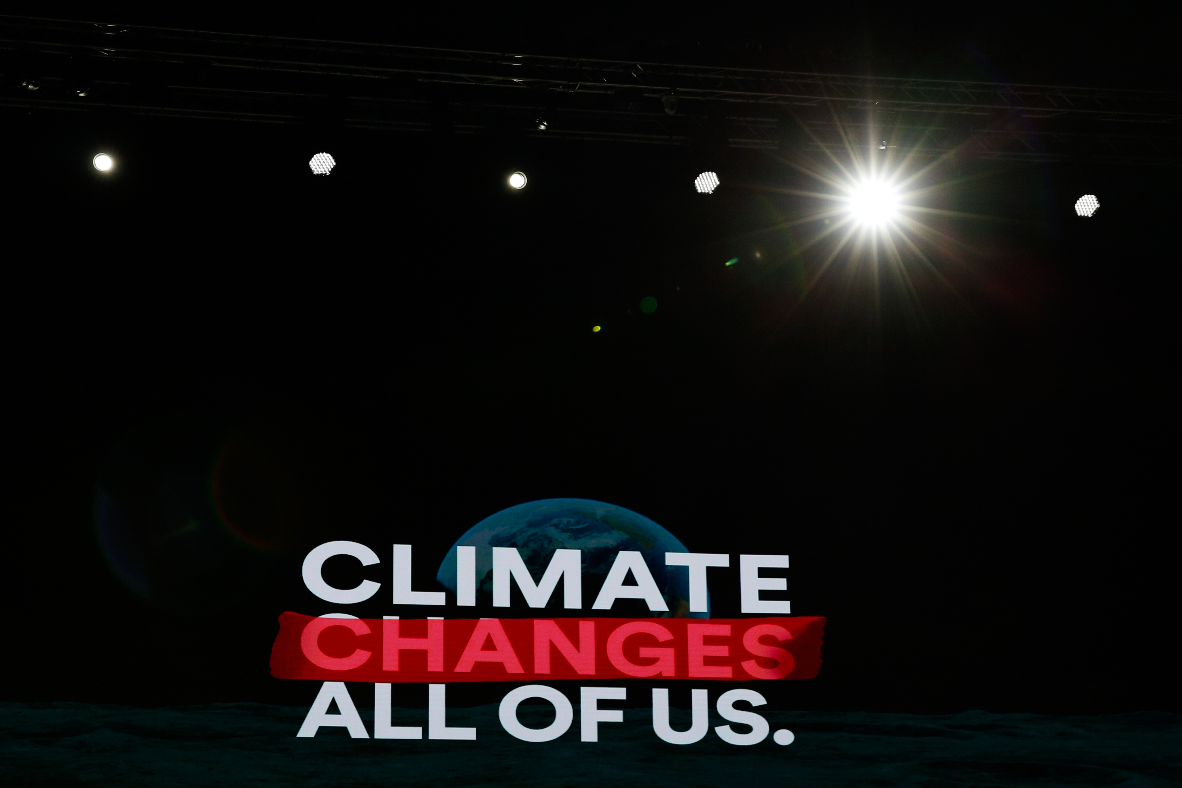 Picture of a widescreen with the words 'climate changes all' of us' with the word changes highlighted in red.