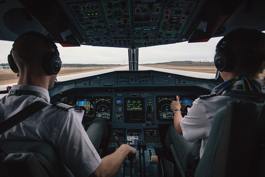 Two pilots sitting the cockpit of an aircraft