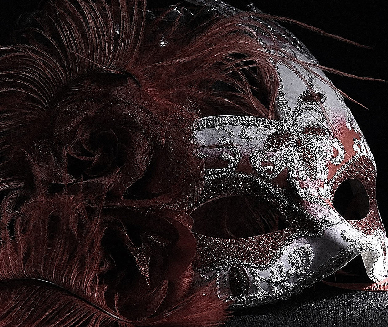 A feather and glitter decorated mask