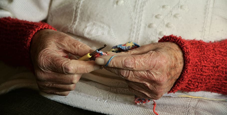 a picture showing an elderly person's hand doing some knitting.