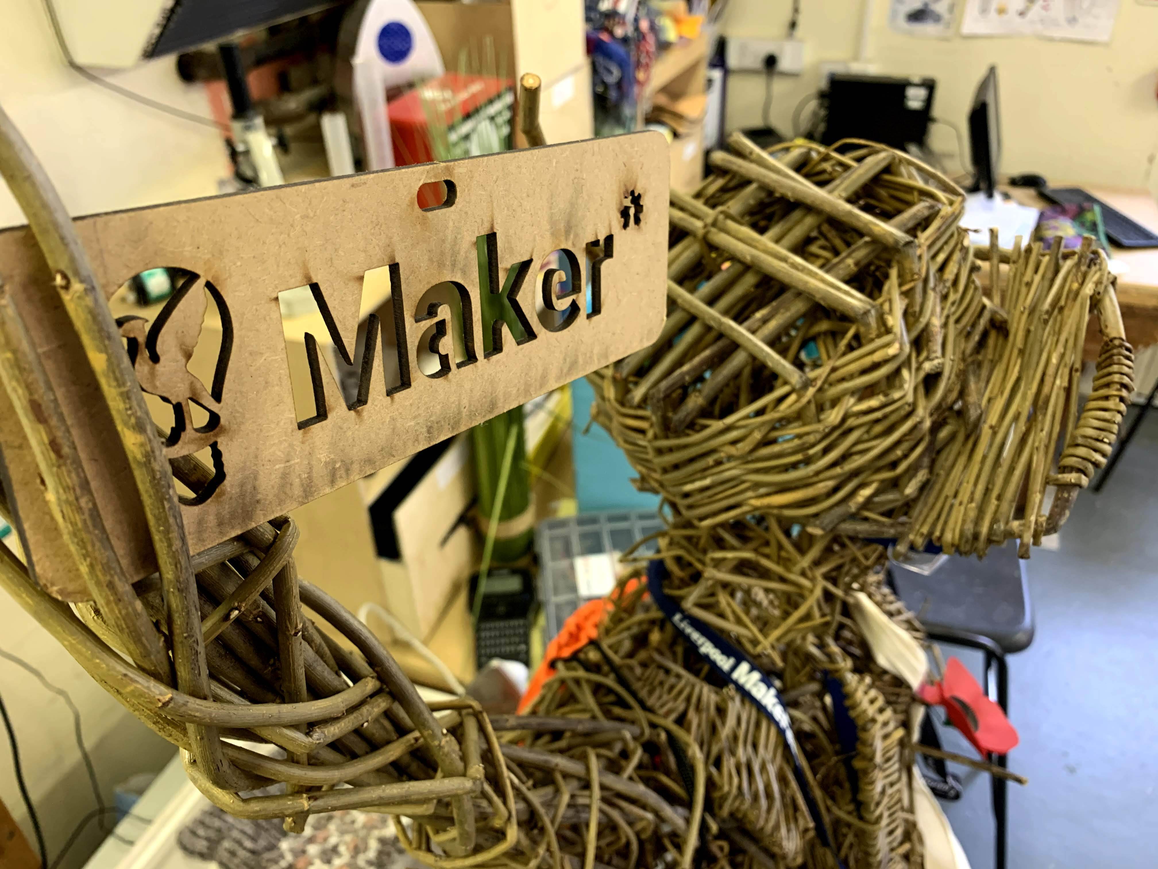 A wicker model of a person with a maker sign