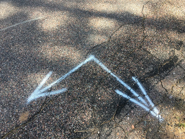 Blue arrows on tarmac marking two directions