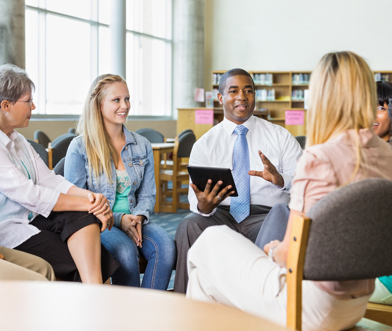 Man leading discussion group of adults