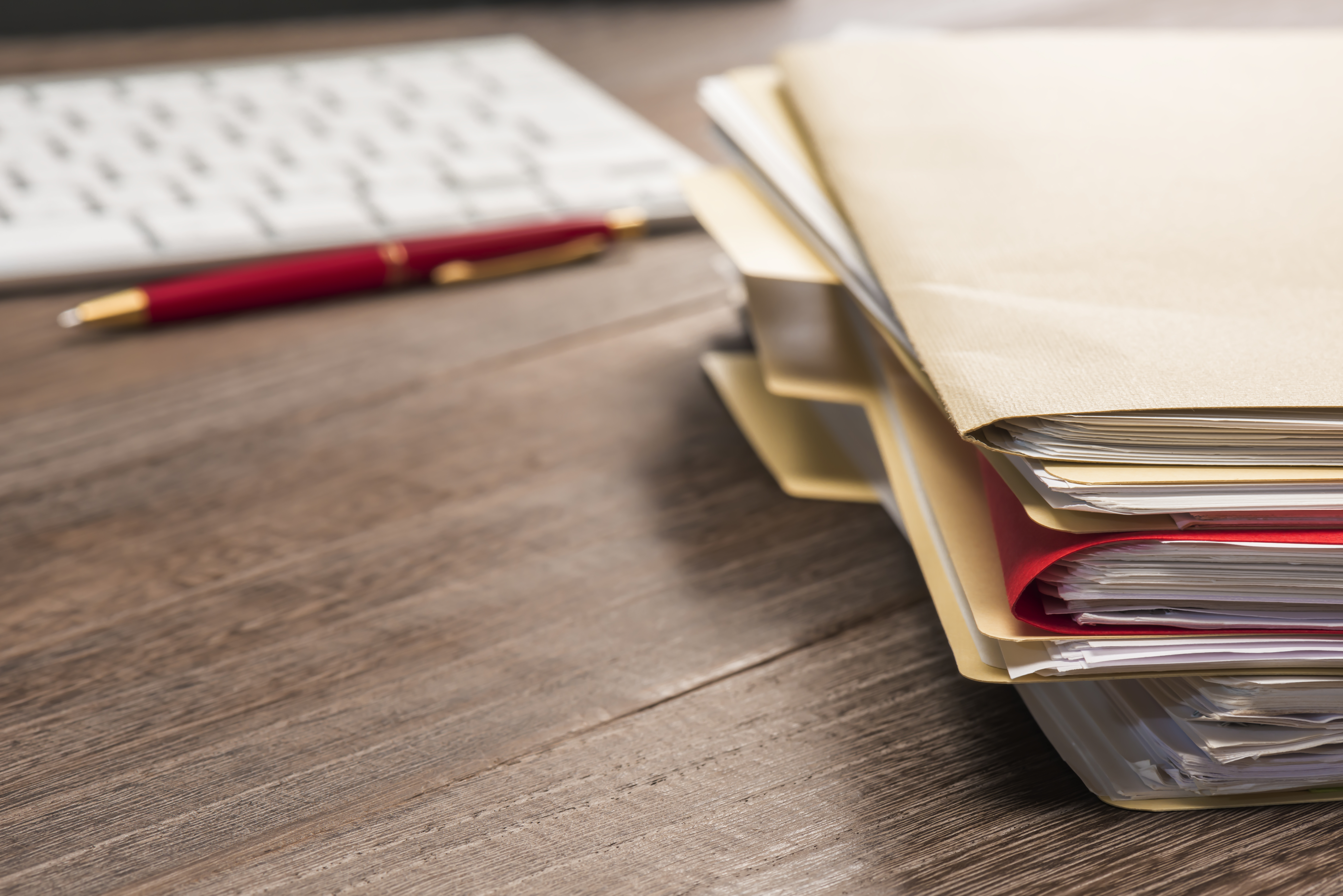 Stacked files  and paperwork on a desk