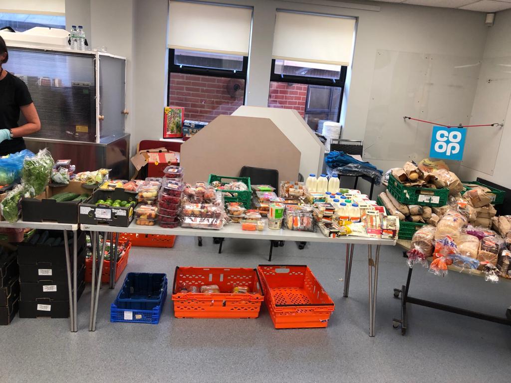 Tables laden with fresh fruit and vegetables, baked goods, milk and sandwiches