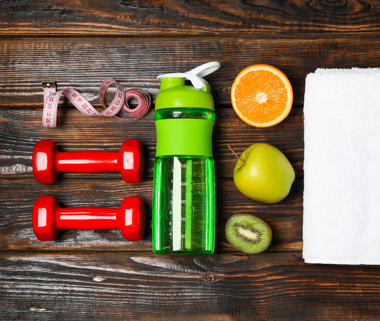 Flat lay composition with healthy lifestyle accessories on wooden background.