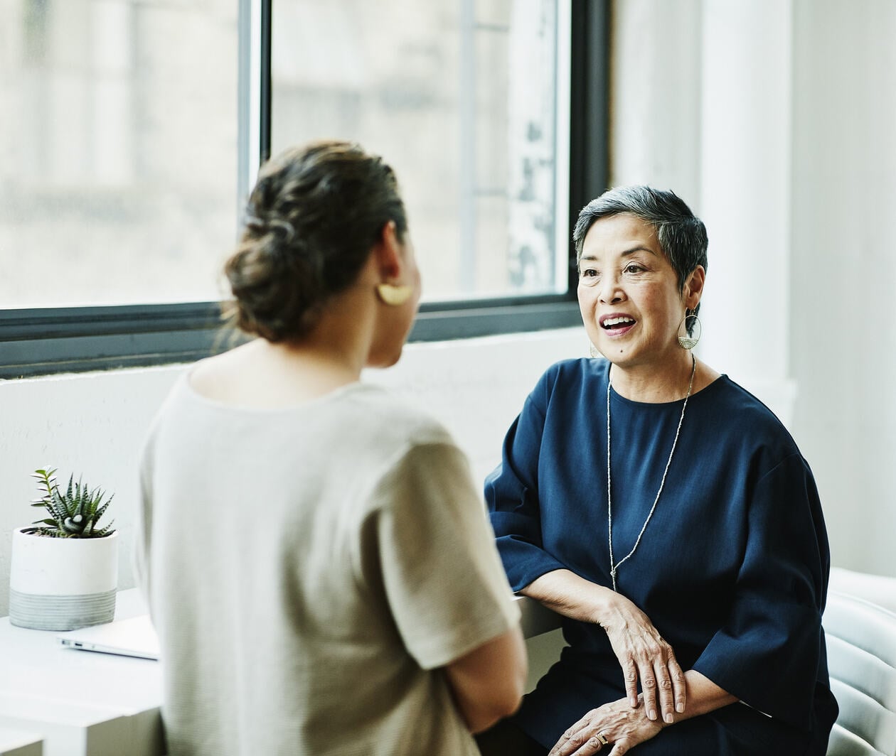 Smiling woman in discussion with client in office conference room