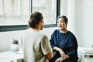 Smiling woman in discussion with client in office conference room