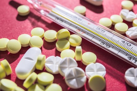 photo close-up of pills and thermometer.