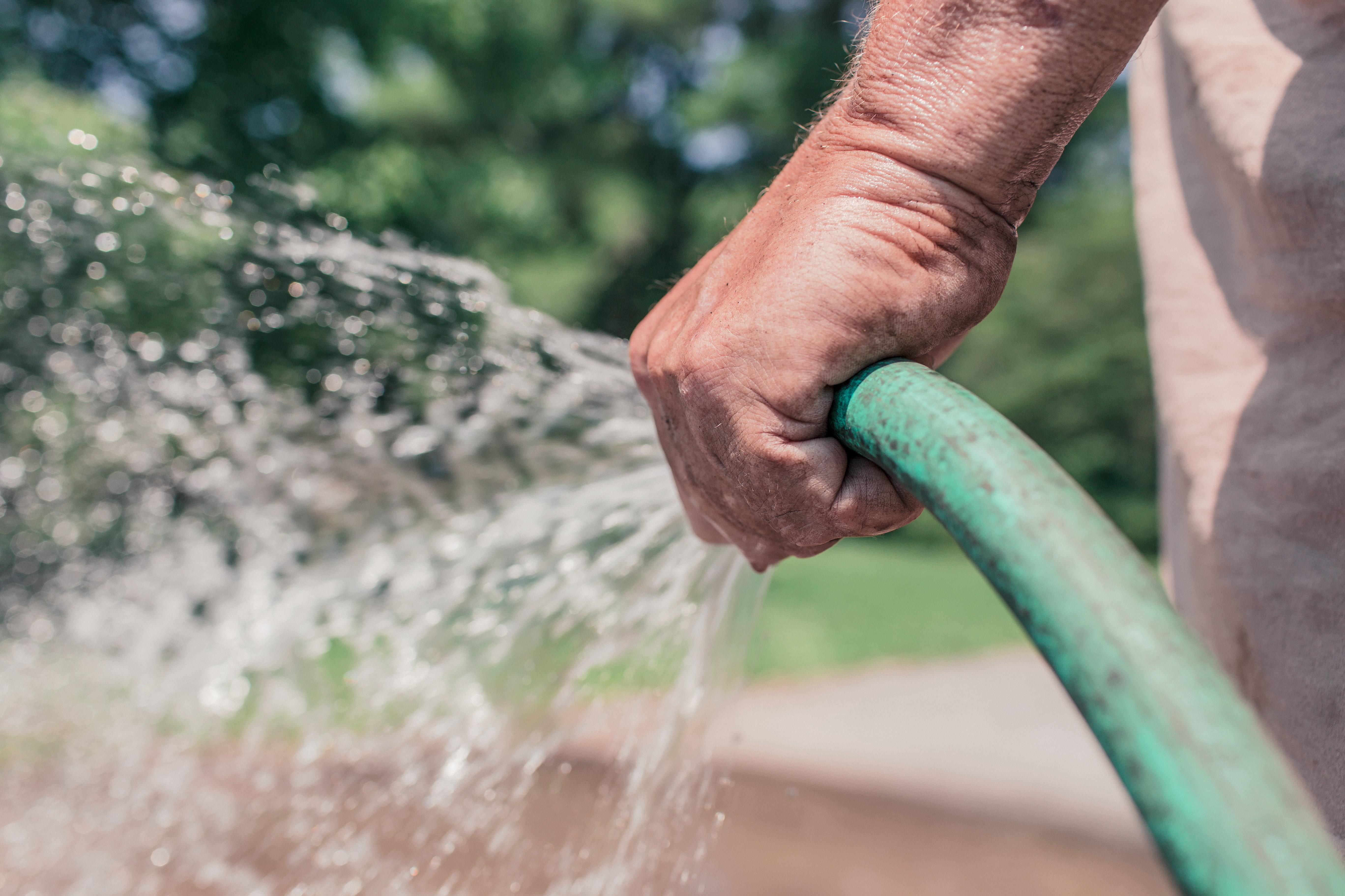 a male hand holding a hose