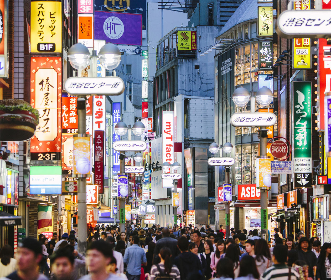 A busy shopping street in an Asian city with illuminated signs