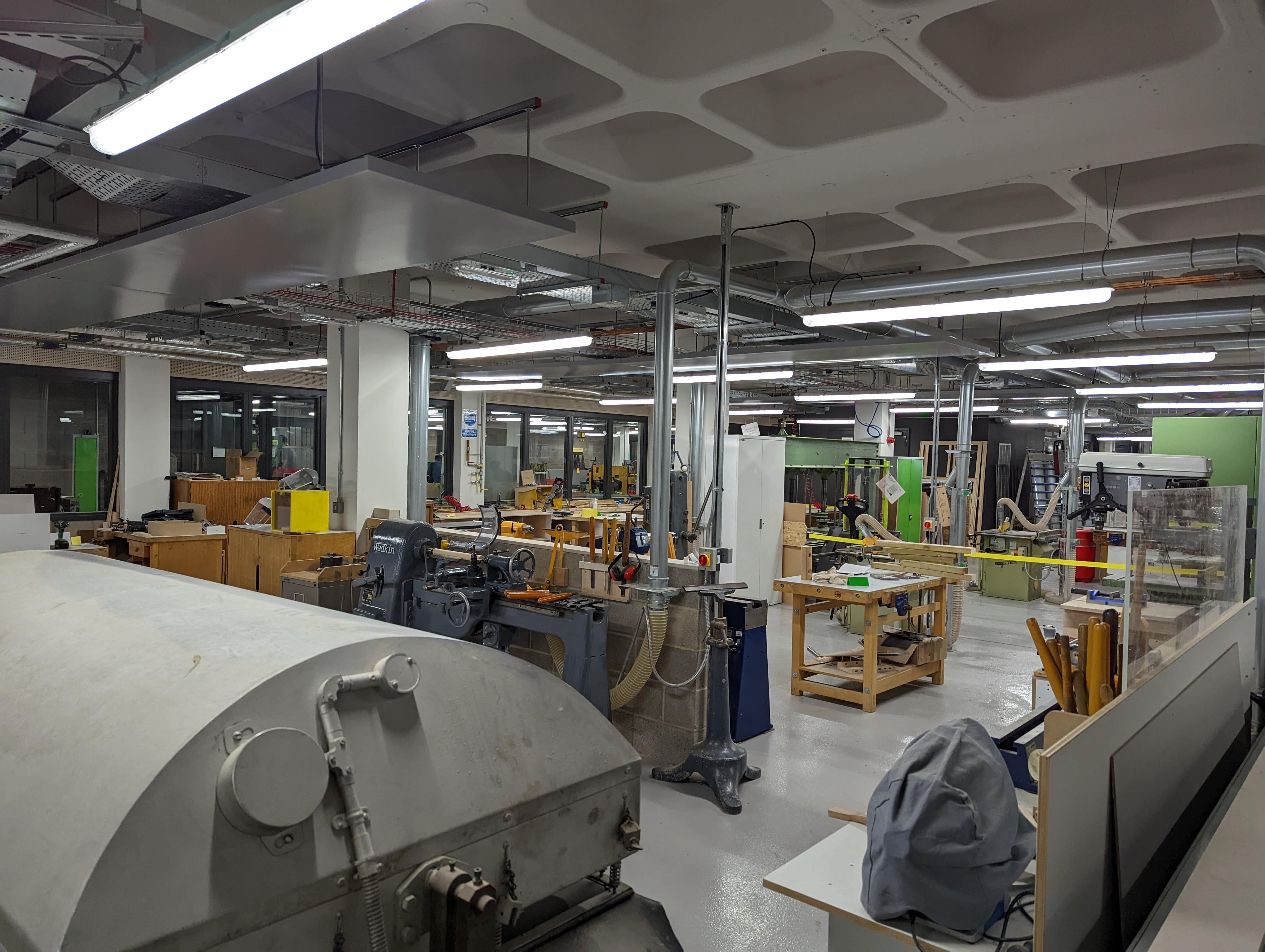 Kingston's wood work room. An open space filled with various large machinery.