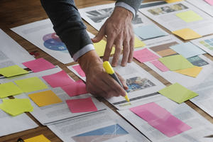Sticky notes on a table and hands rearranging them